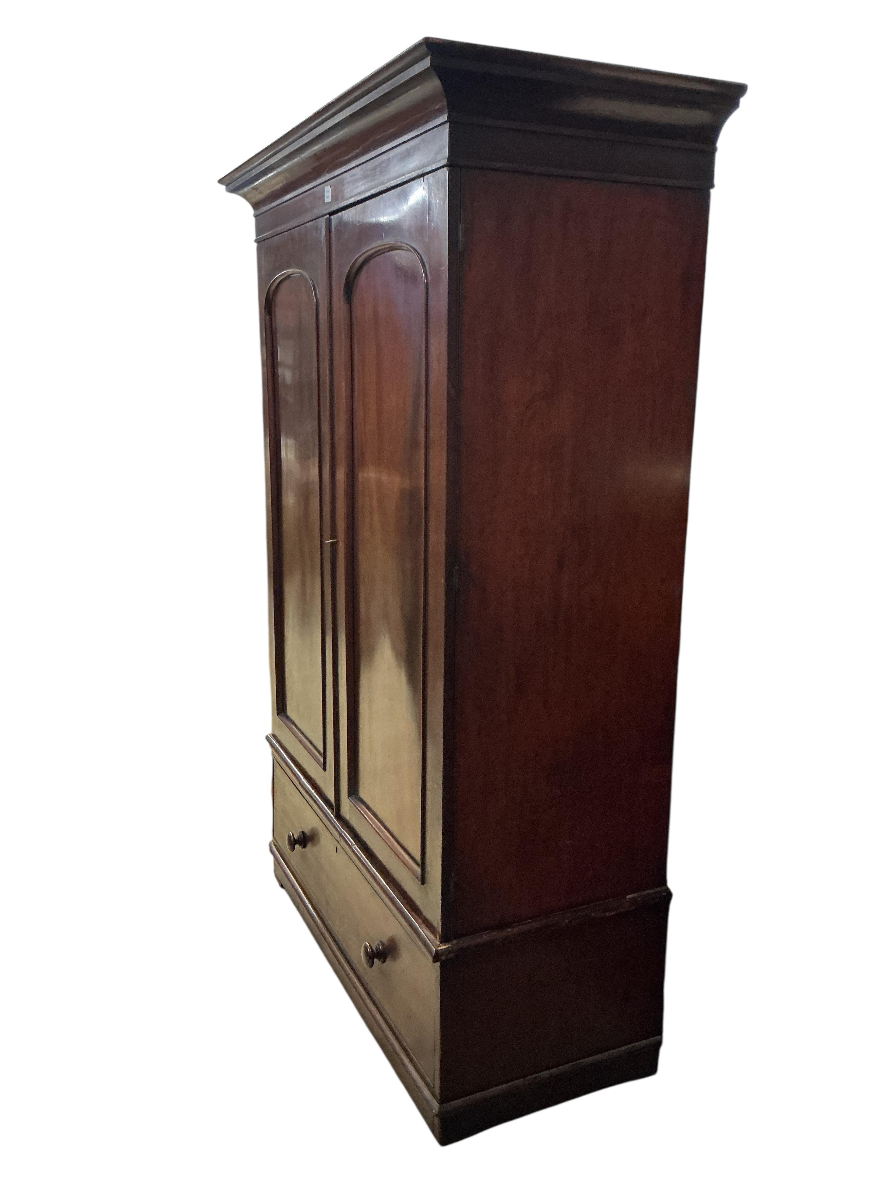 A Victorian mahogany two door wardrobe, fitted with a base drawer, width 140cm, depth 63cm, height 206cm